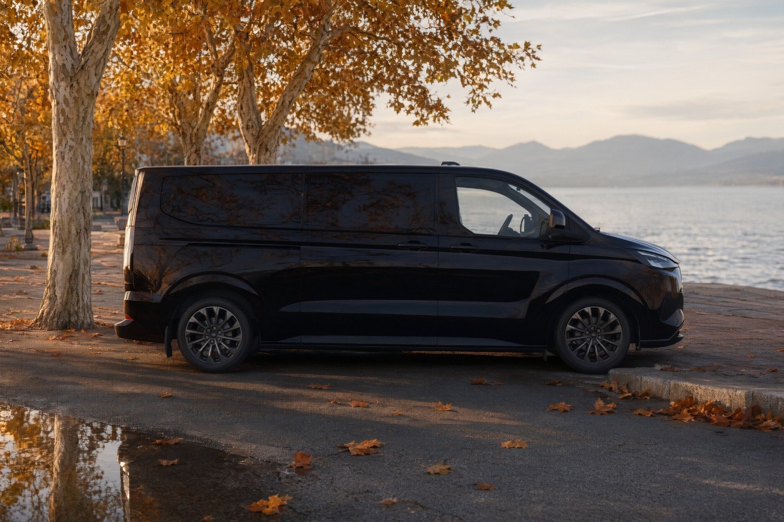 Ford Tourneo Custom noir vu de profil sur une promenade au bord du lac